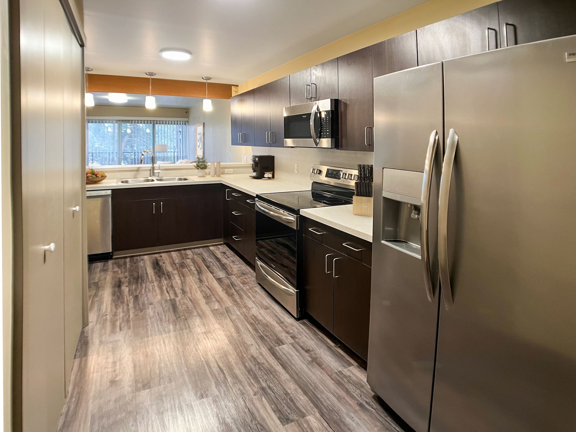 A kitchen with stainless steel appliances and wooden floors