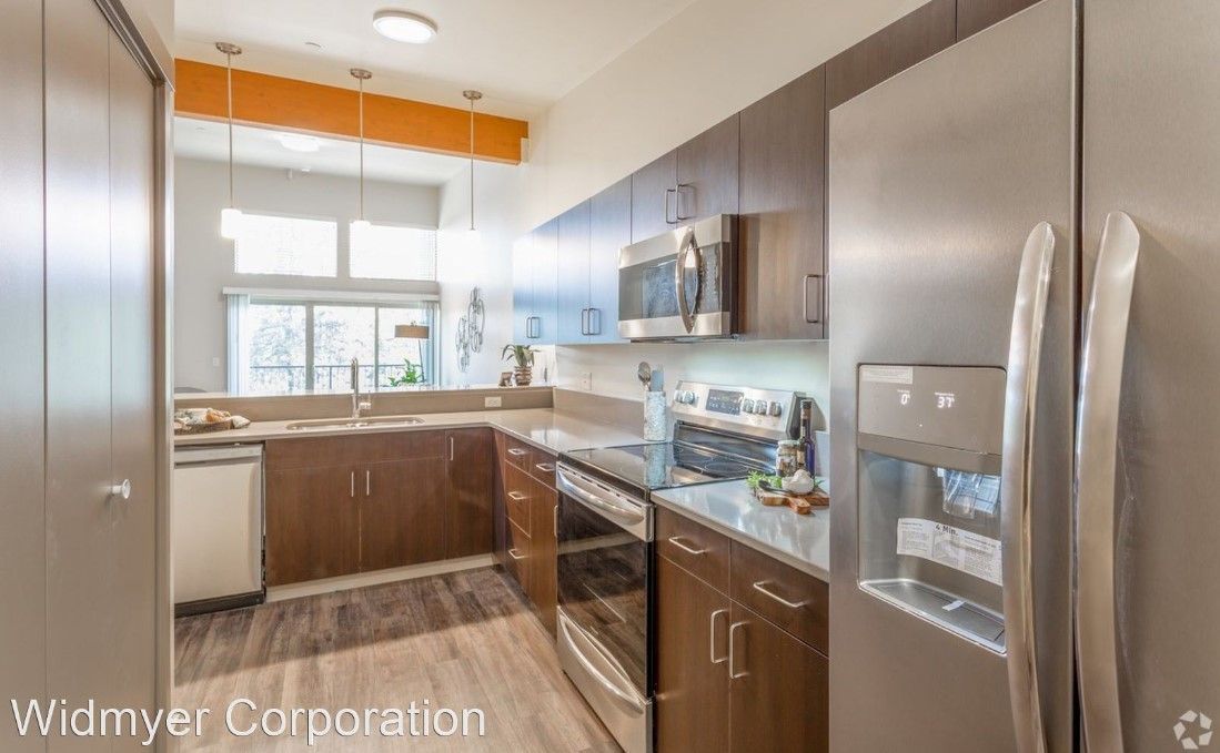 A kitchen with stainless steel appliances and wooden cabinets.