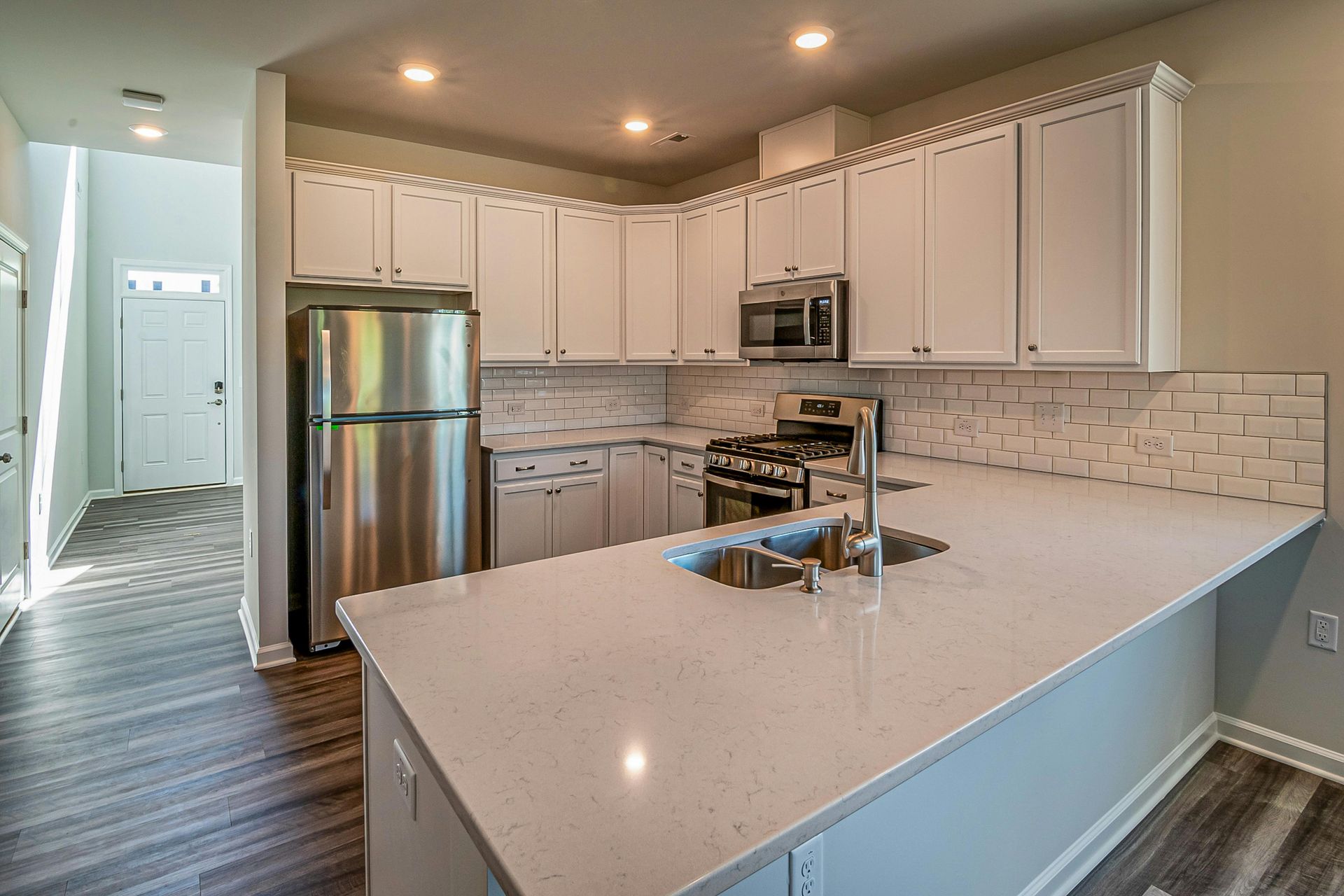 Modern kitchen with white cabinets, stainless steel appliances, and a gray countertop.