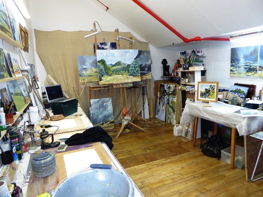 A painting studio with a lot of paintings on display