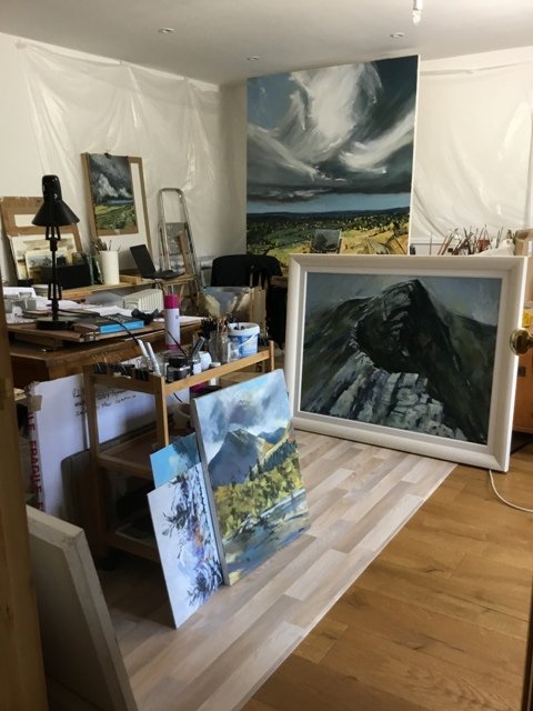 A room with a lot of paintings on the floor