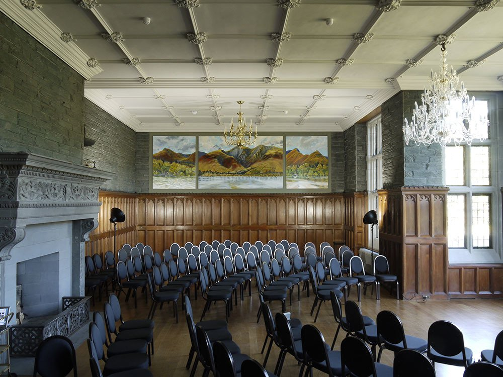 A large room with a lot of chairs and a fireplace
