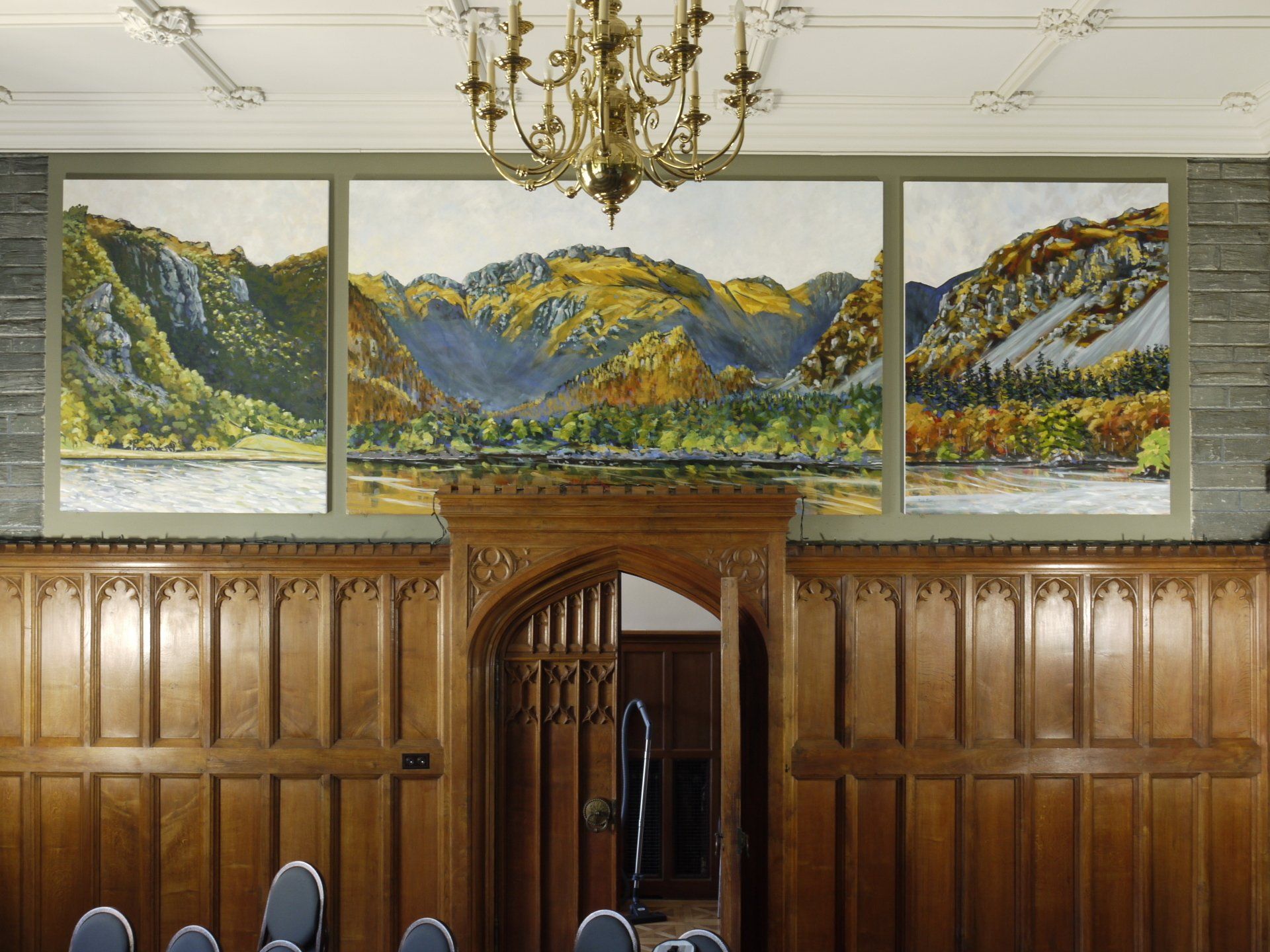 A room with a painting of mountains on the wall