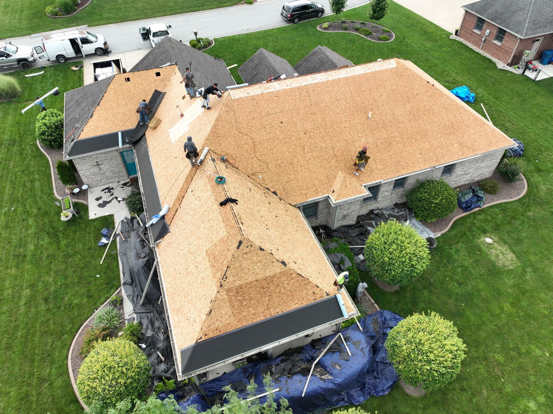 An aerial view of a house with a new roof being installed.