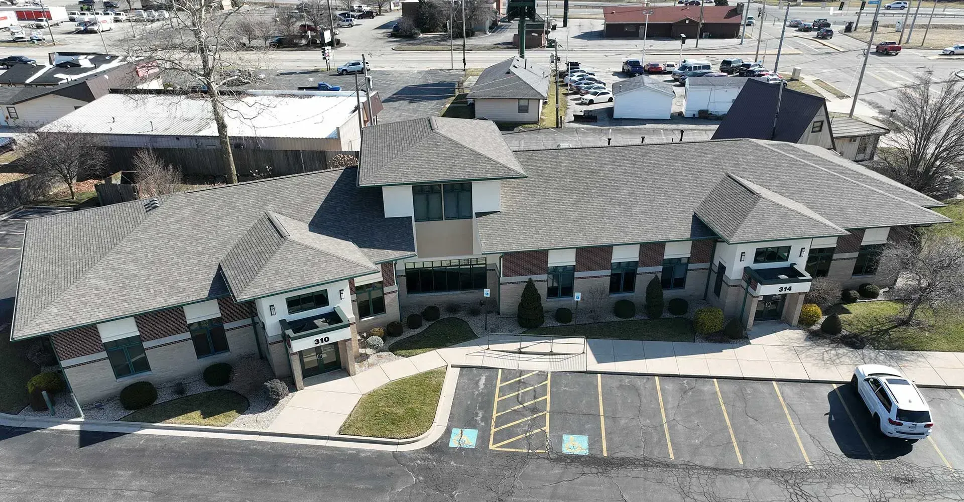 An aerial view of a large building with a parking lot in front of it.