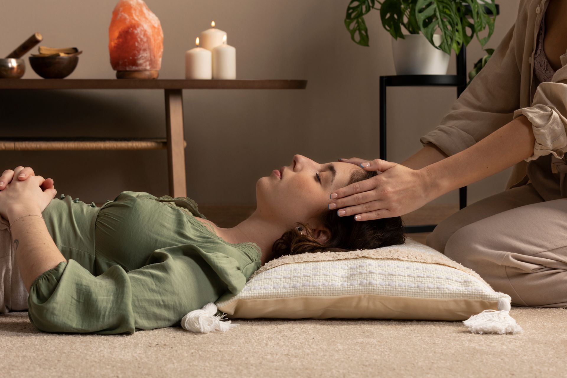Woman receiving a relaxing head touch in a tranquil setting.