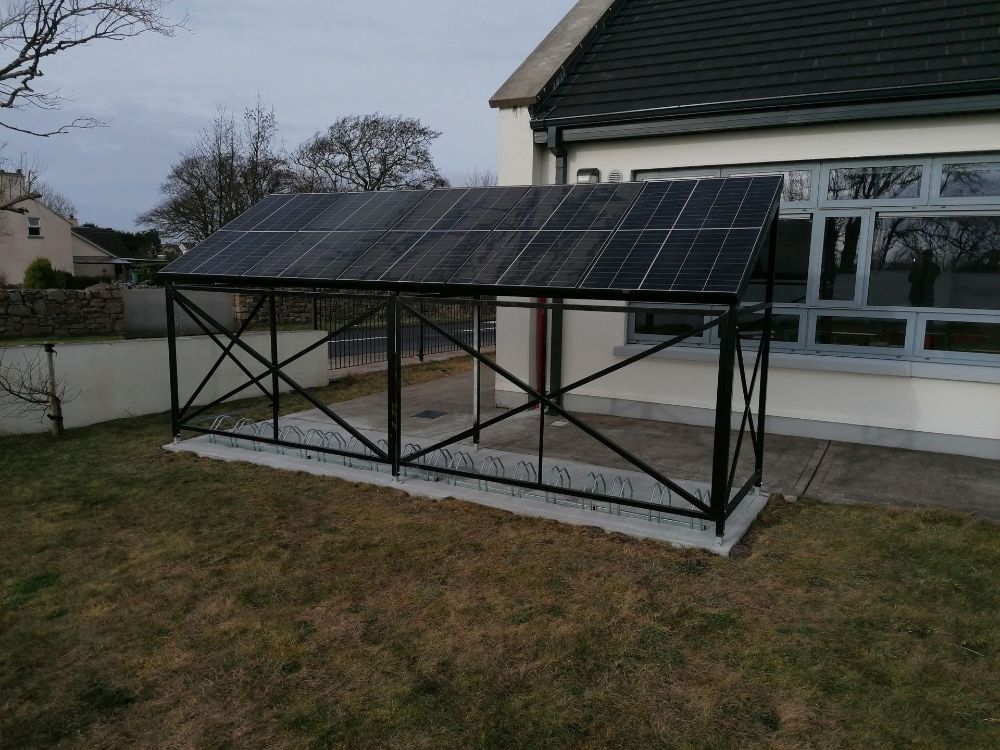 A solar panel is sitting on top of a metal structure in front of a house.