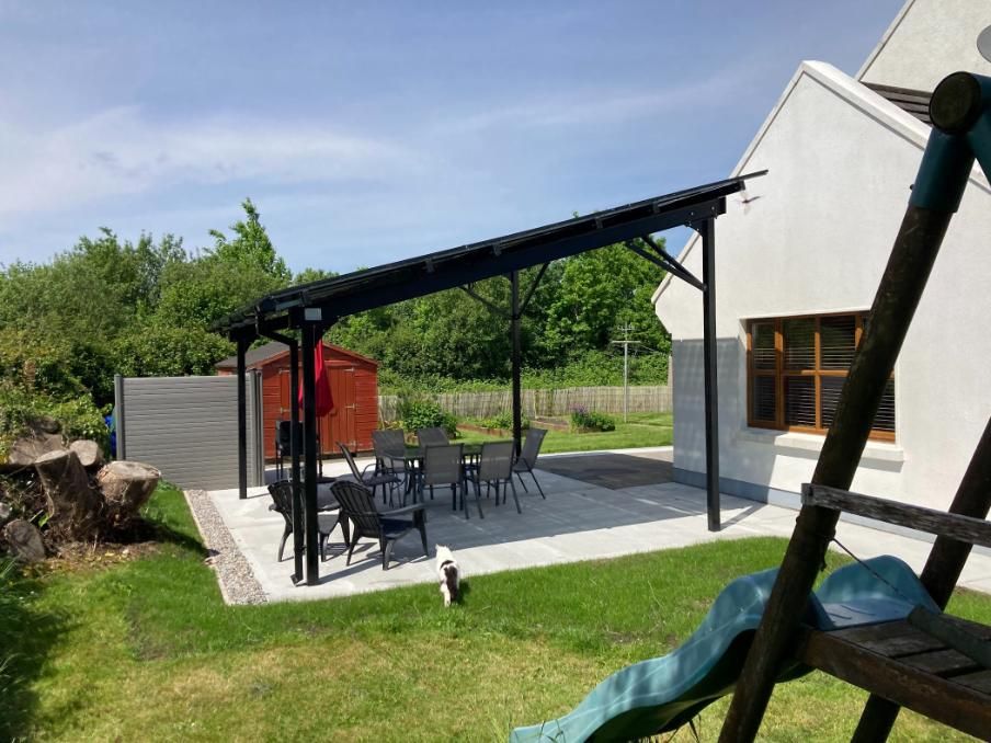 A patio with a table and chairs in front of a house.