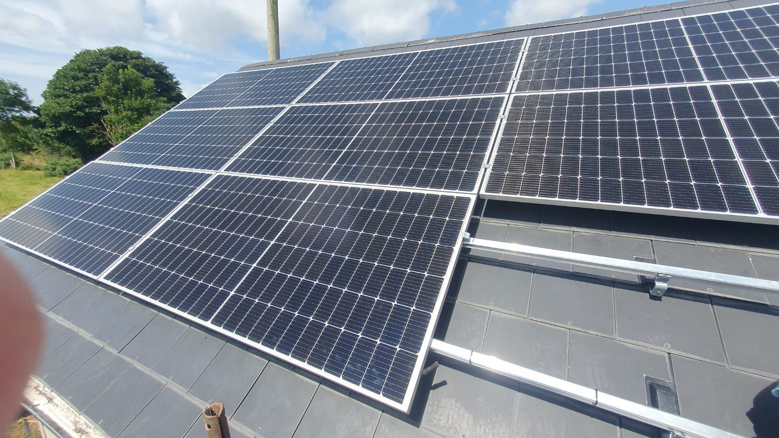A row of solar panels are sitting on top of a roof.