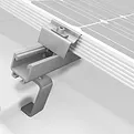 Metal clamp securing a solar panel to a mounting track.