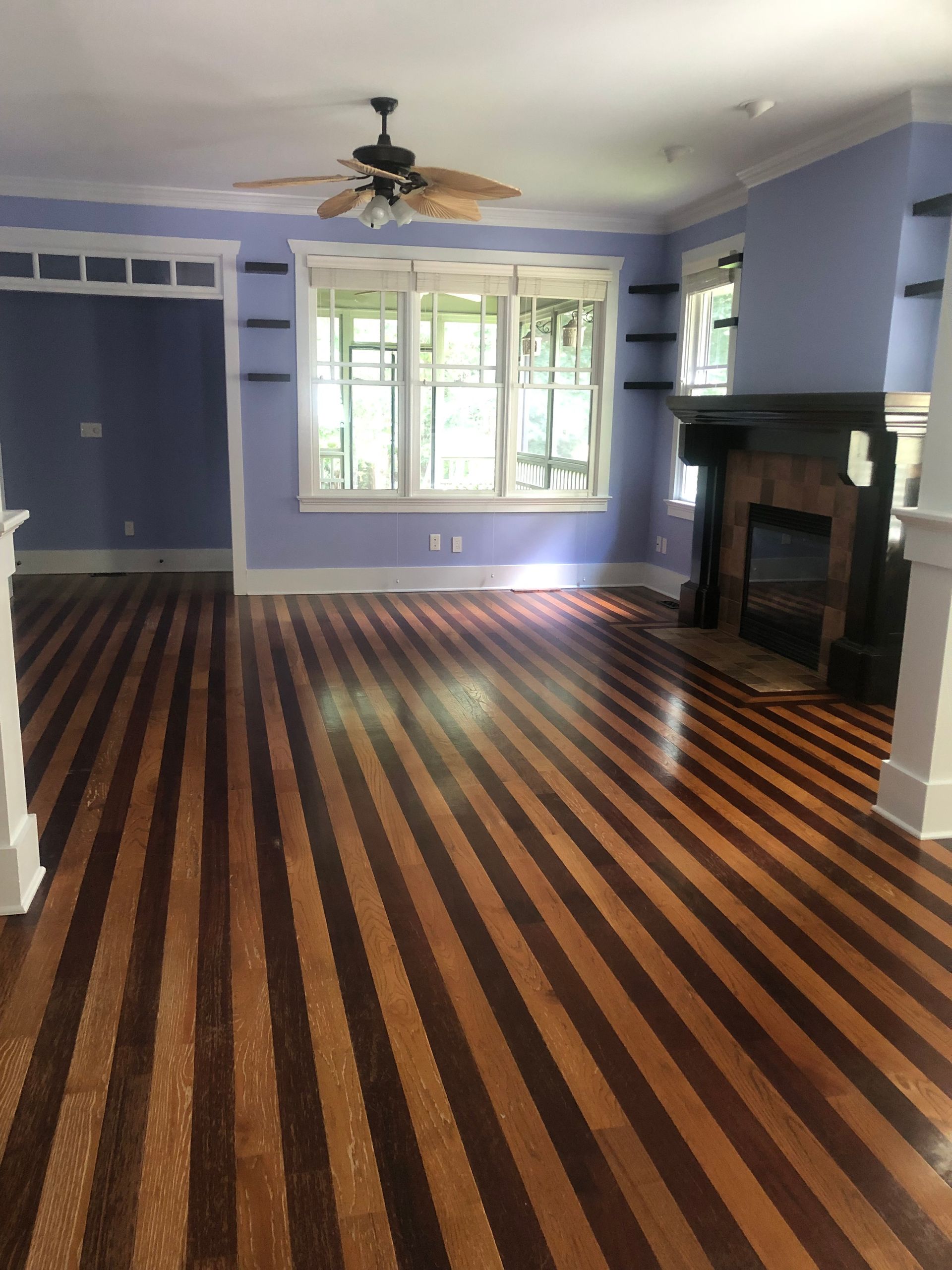 A living room with a striped floor and a fireplace