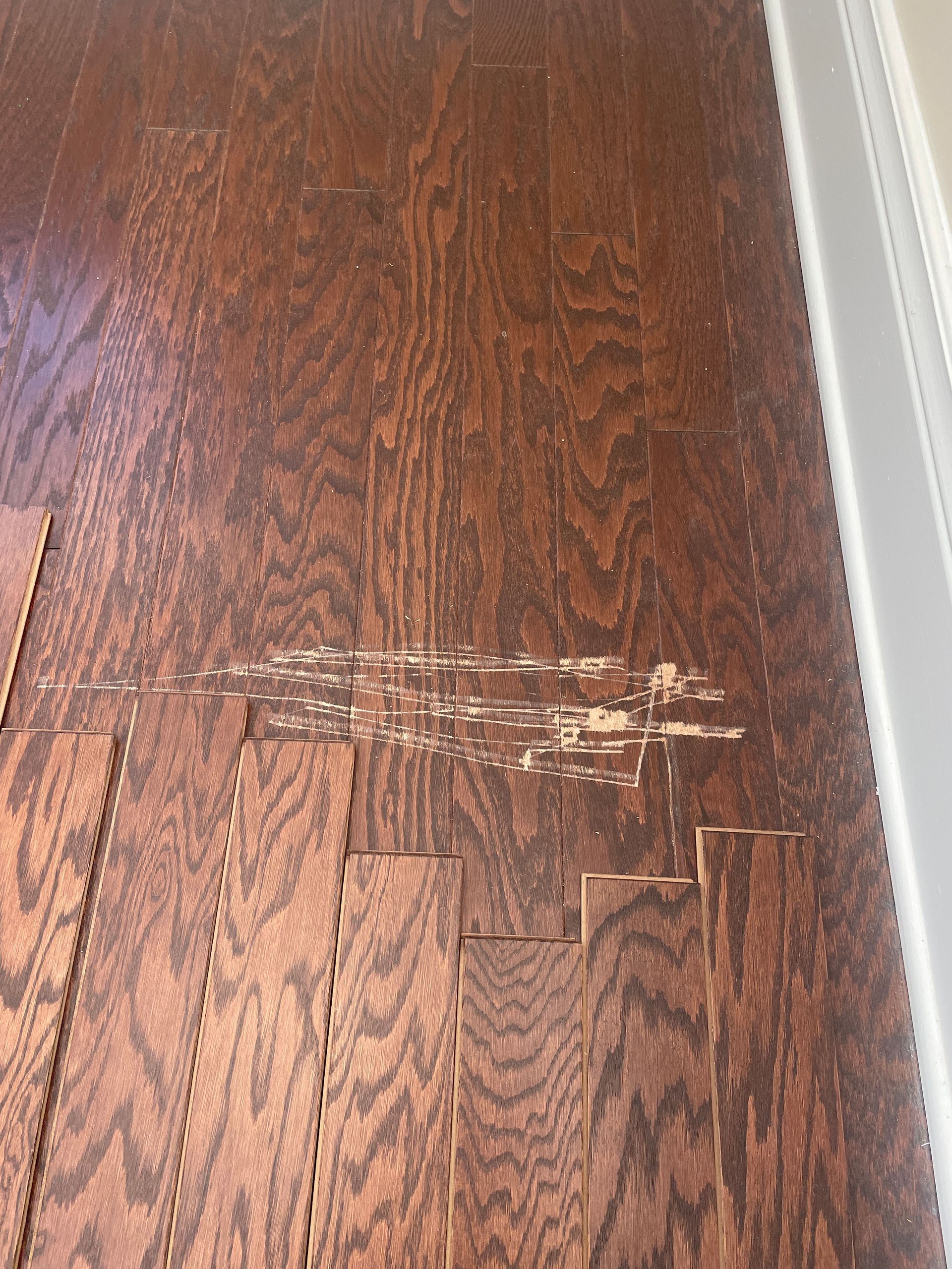 A close up of a wooden floor with scratch marks.