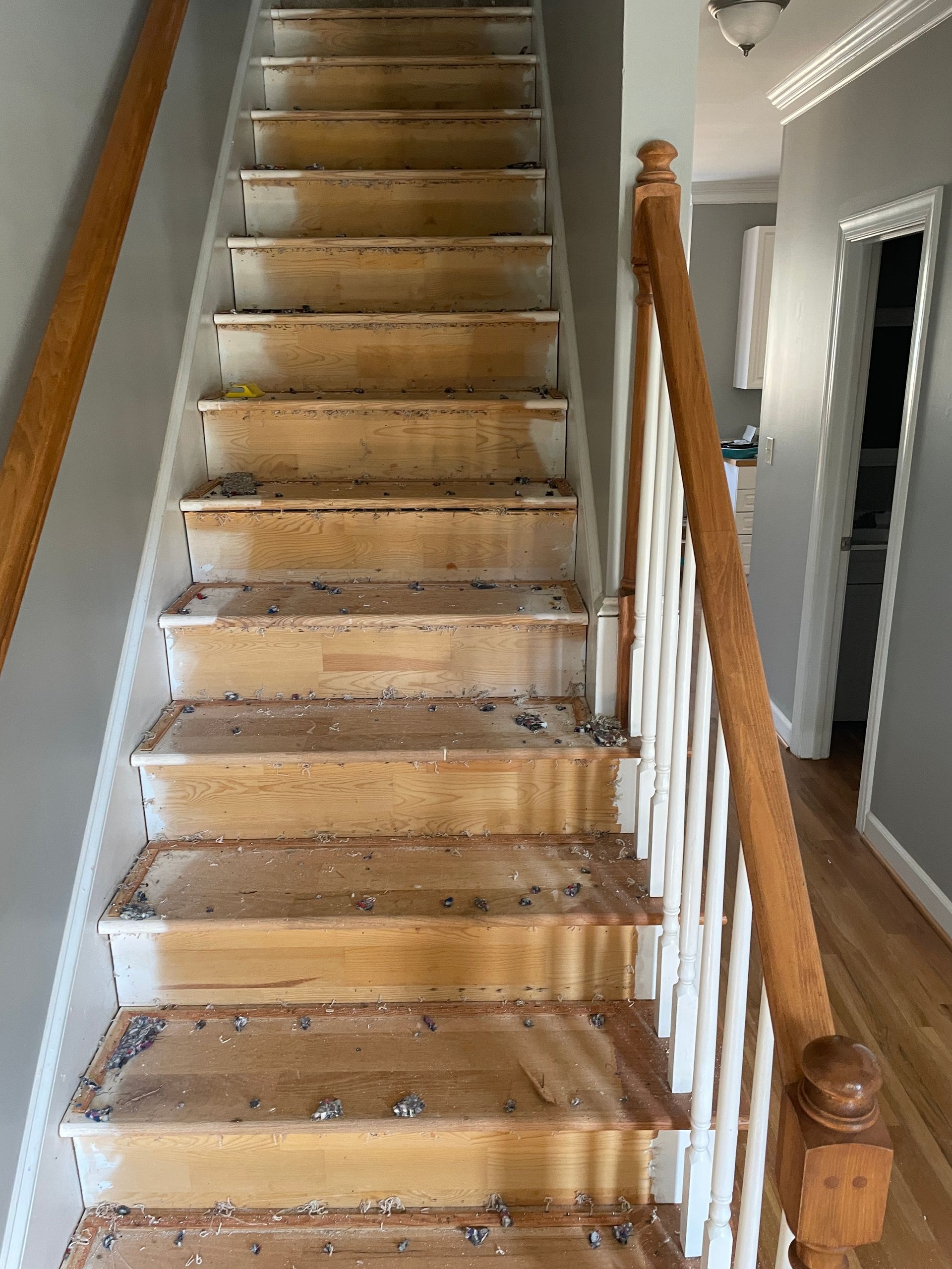 A wooden staircase with a white railing in a house.