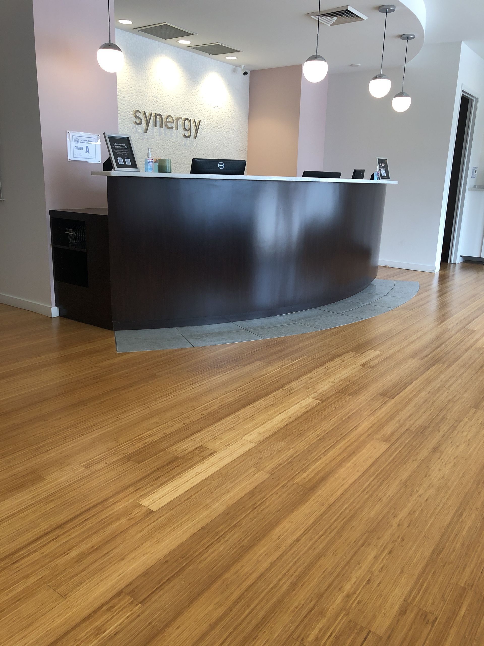 Reception area with wooden floors and curved dark brown reception desk;