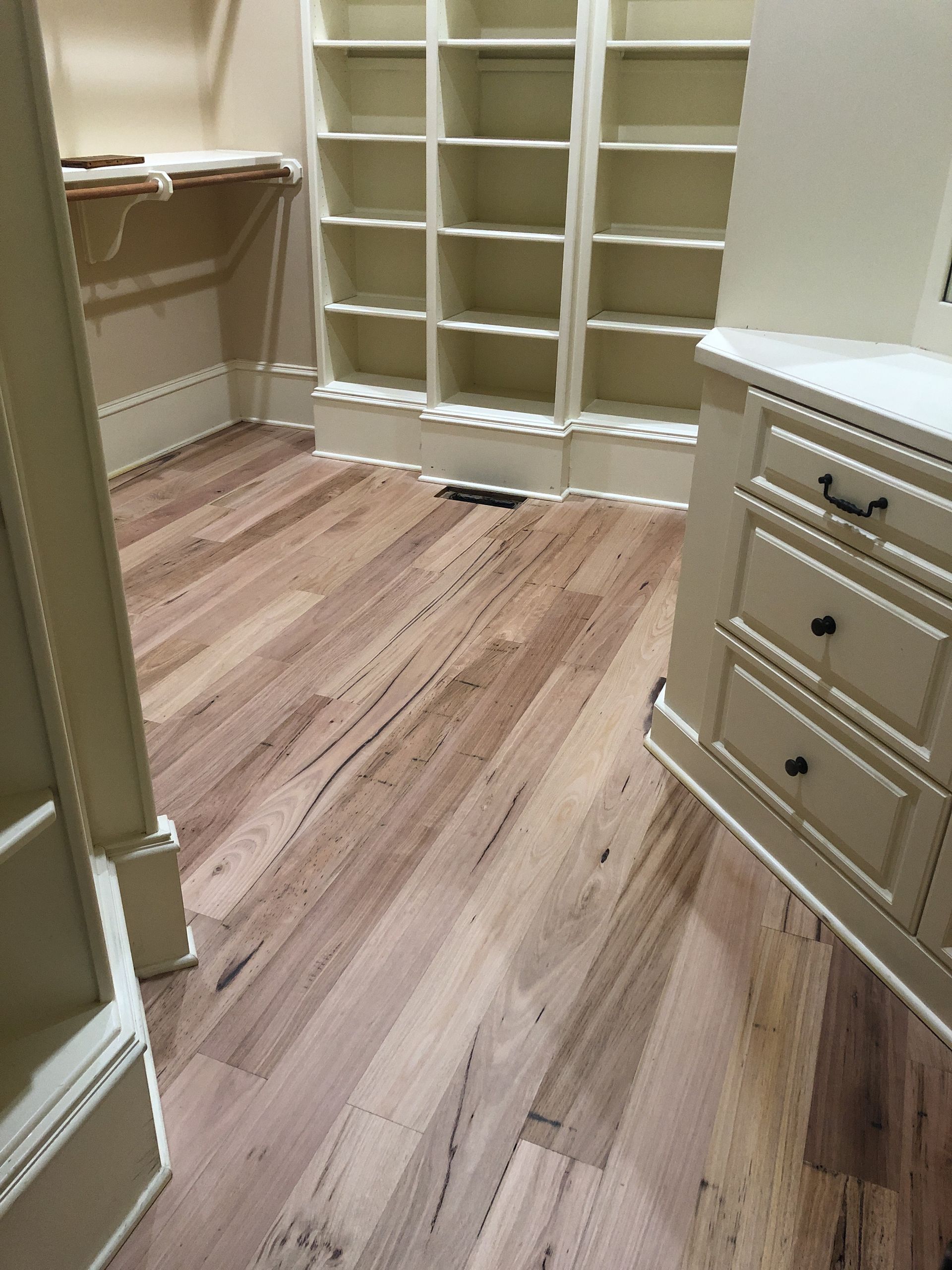 Wooden floor in a room with white built-in shelves and a cabinet. North Raleigh NC.