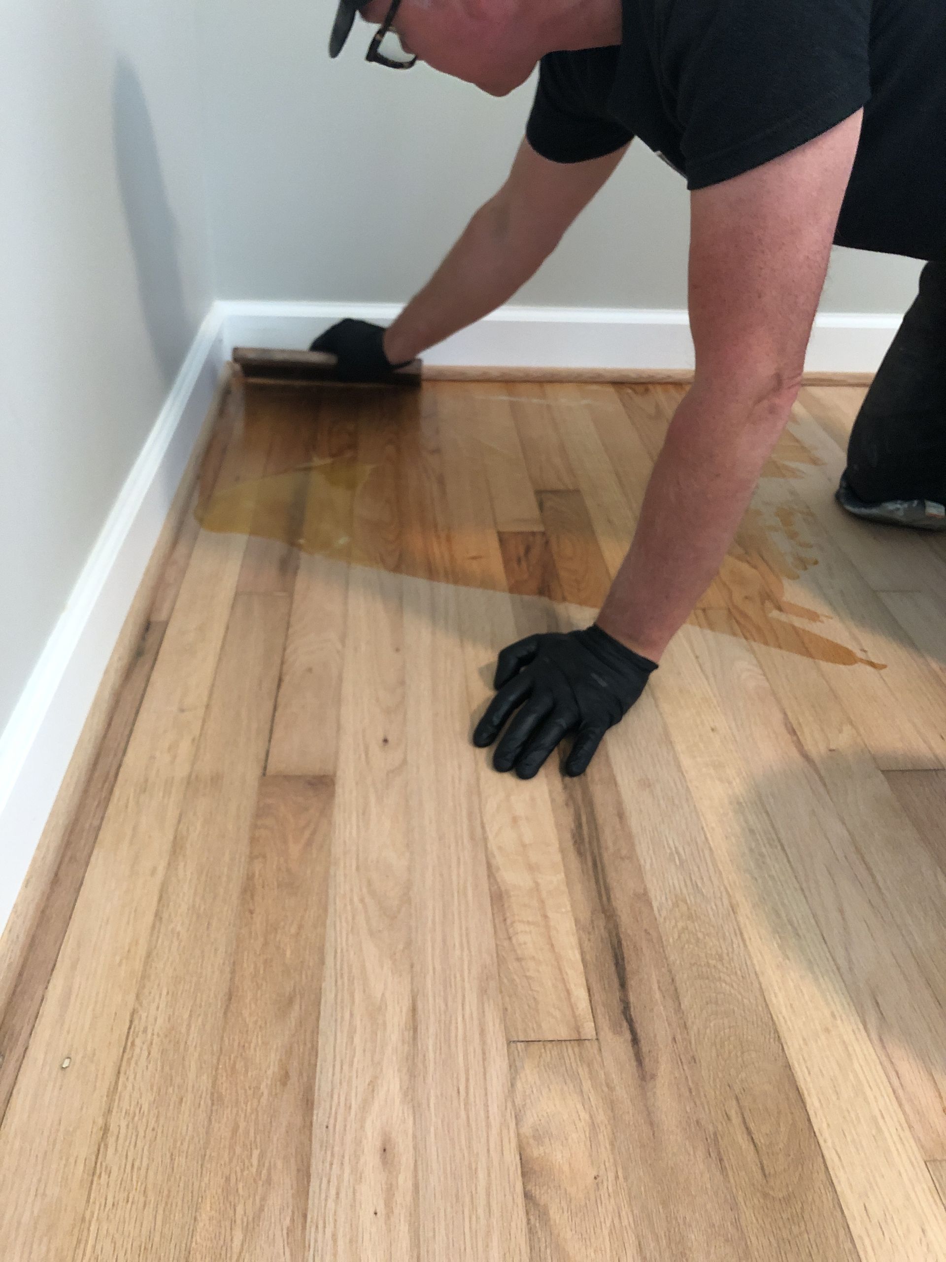 Troweling on natural oil finish on a wooden floor.