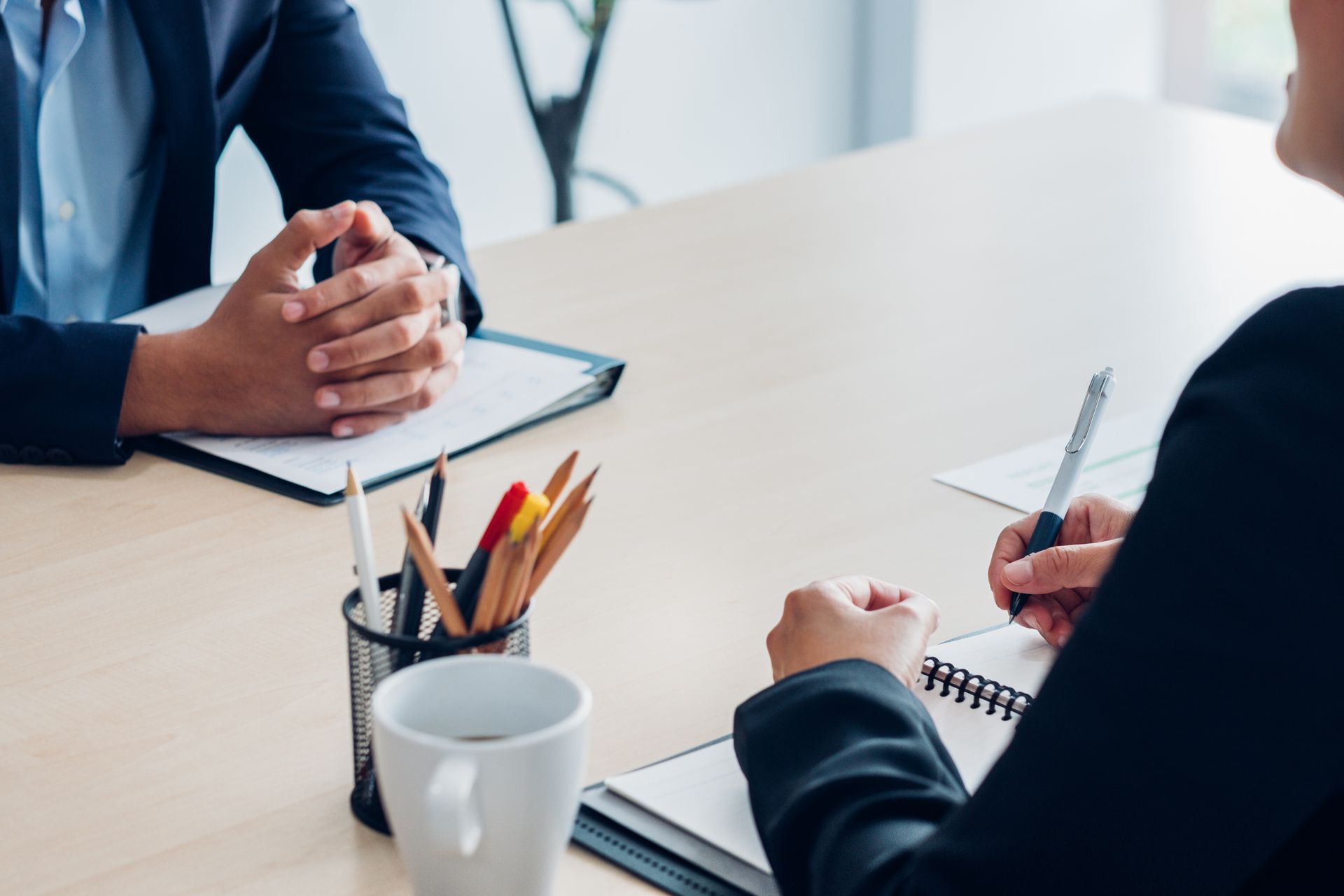 Un homme et une femme sont assis à une table et ont un entretien d'embauche.