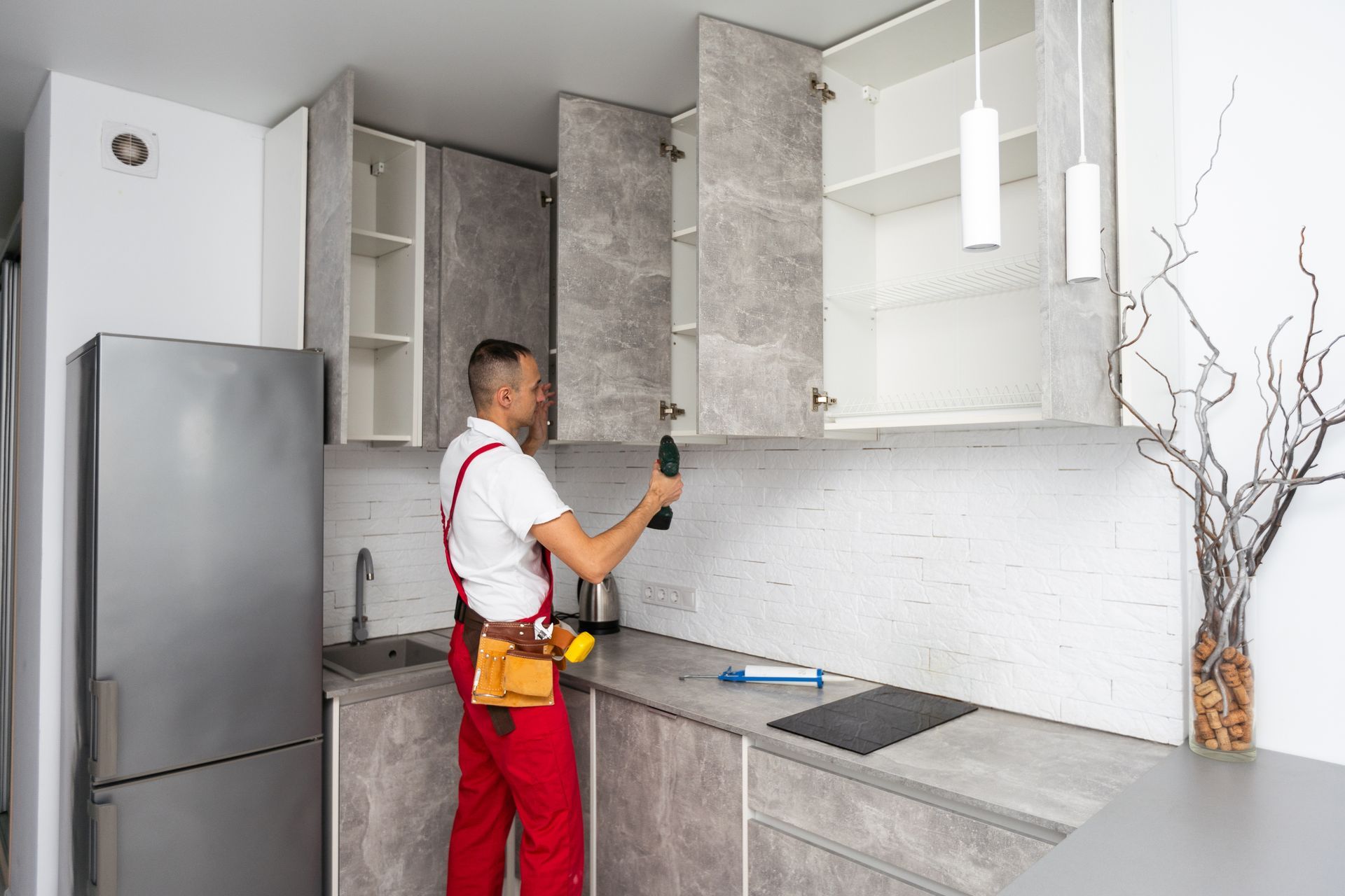 A cabinetmaker is finishing a new kitchen cabinet installation.