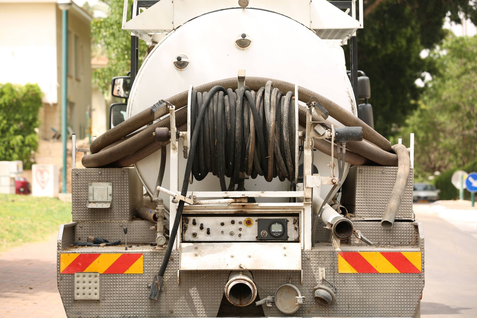 A vacuum truck is parked on the side of the road