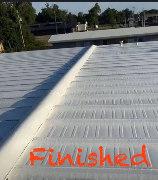 A white metal roof with a central seam ridge, featuring the orange word