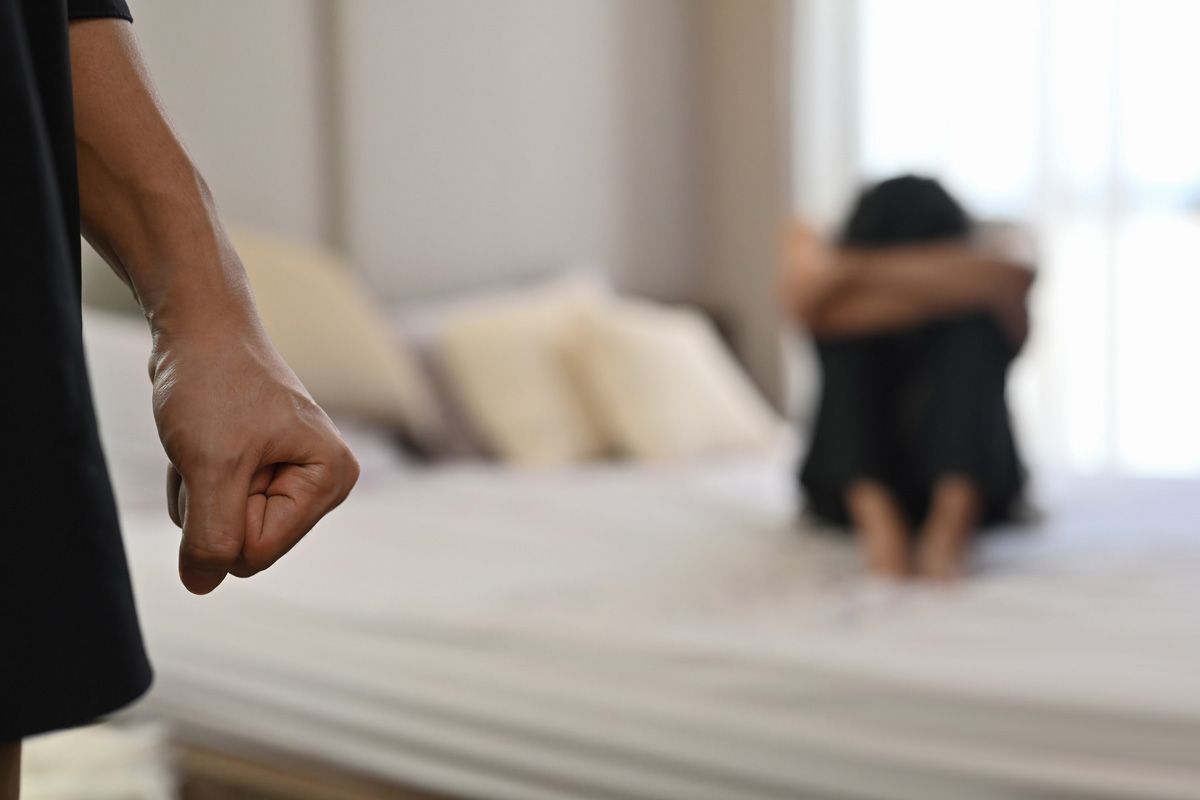 Fist Male with Crying Woman Sits on a Bed — Yuba City, CA — Law Office of Geoffrey J. Heitman