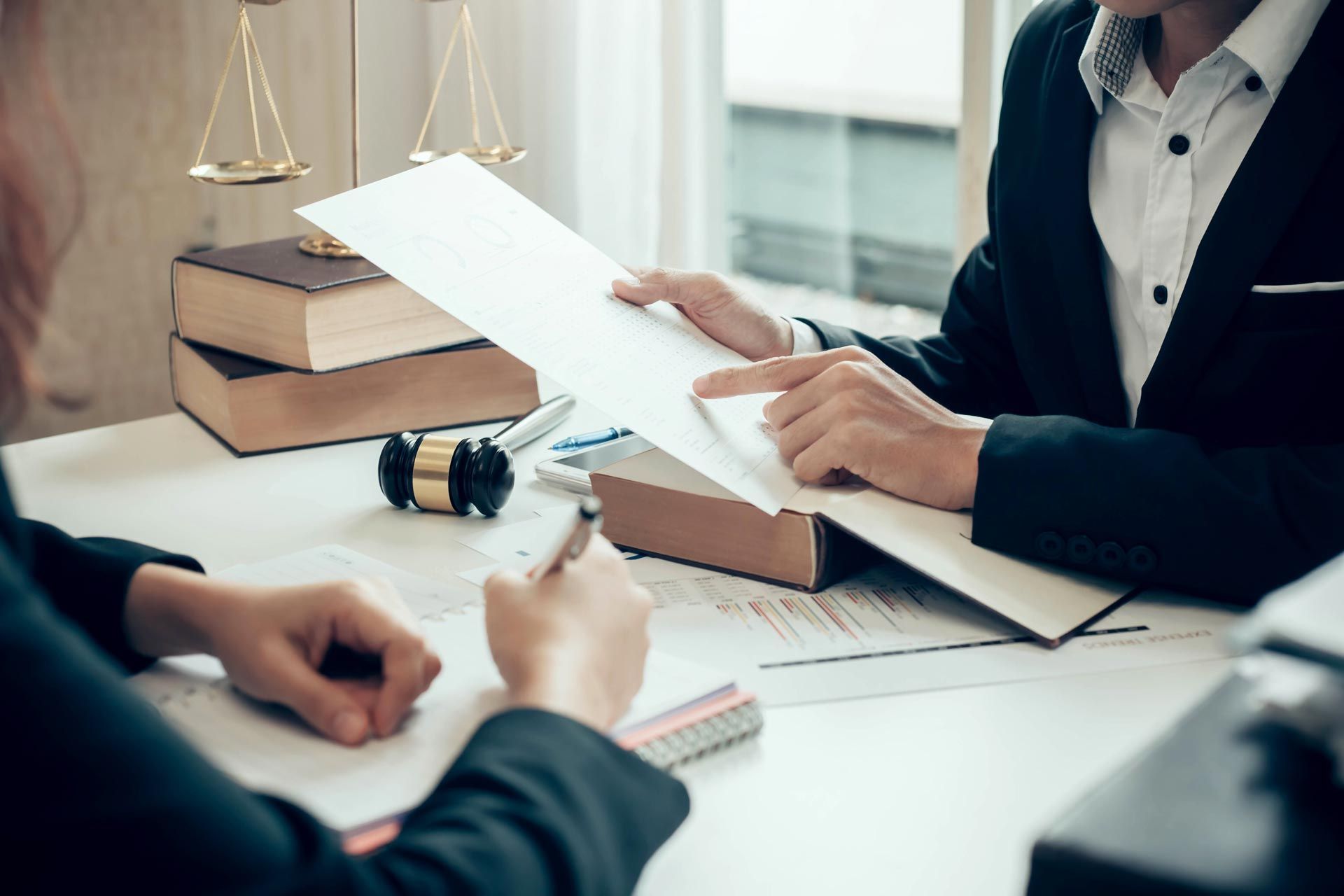 A Chapter 13 bankruptcy attorney discusses the plan with their client in the office. A Chapter 13 bankruptcy attorney discusses the plan with their client in the office.