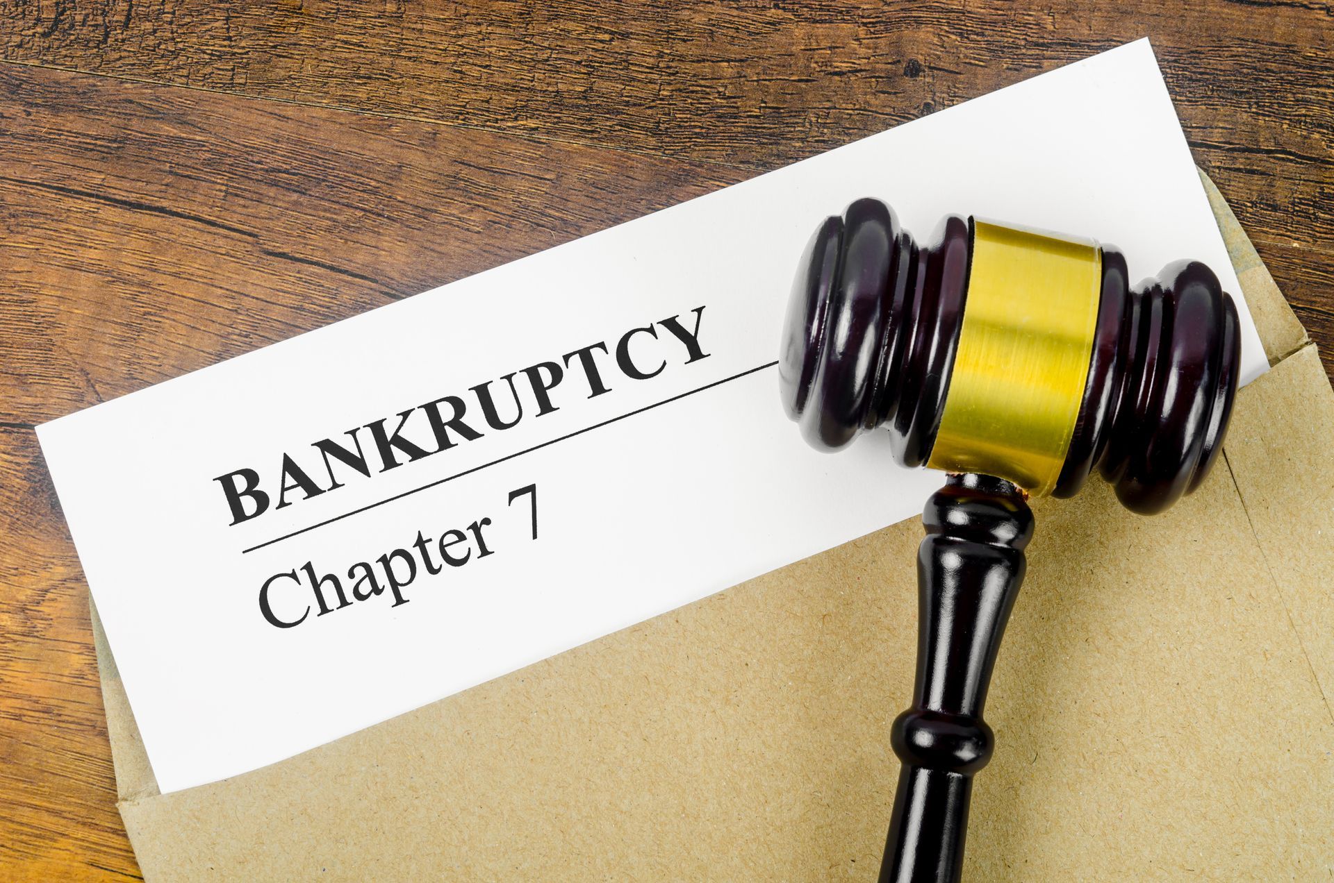 A bankruptcy Chapter 7 text on a document form and a wooden gavel on an office desk.