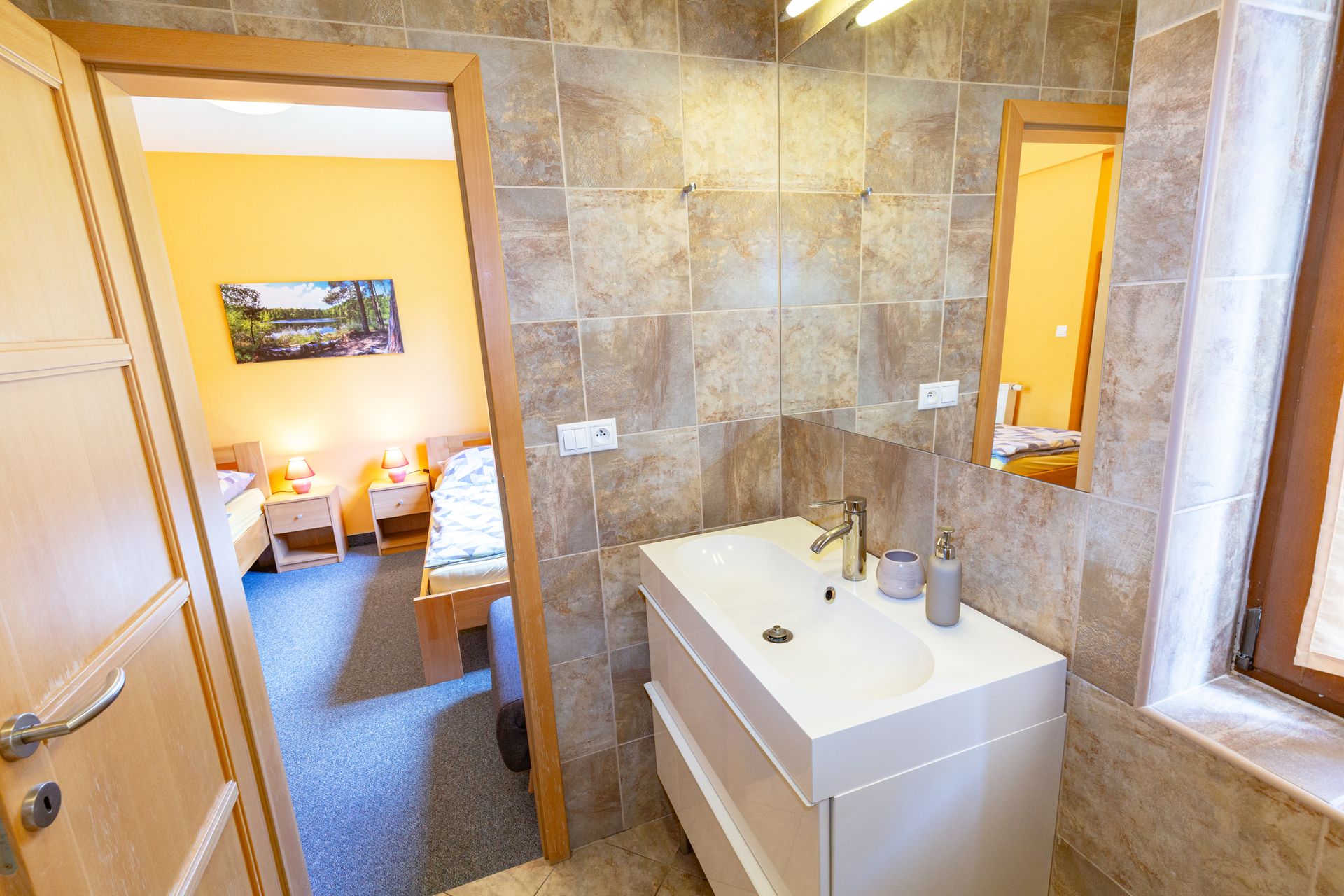 Kúpeľňa s umývadlom a zrkadlom v hotelovej izbe.