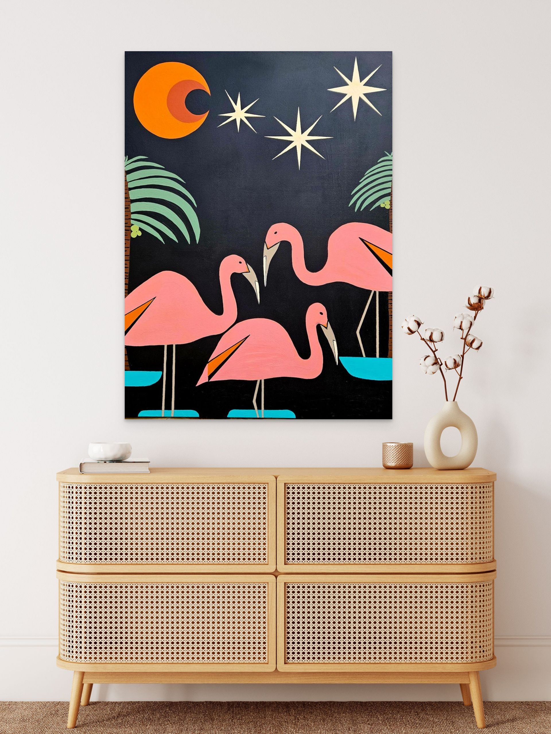 Mid-century style art features three pink flamingos in a night scene with stars, a moon, and palm leaves above a cabinet.