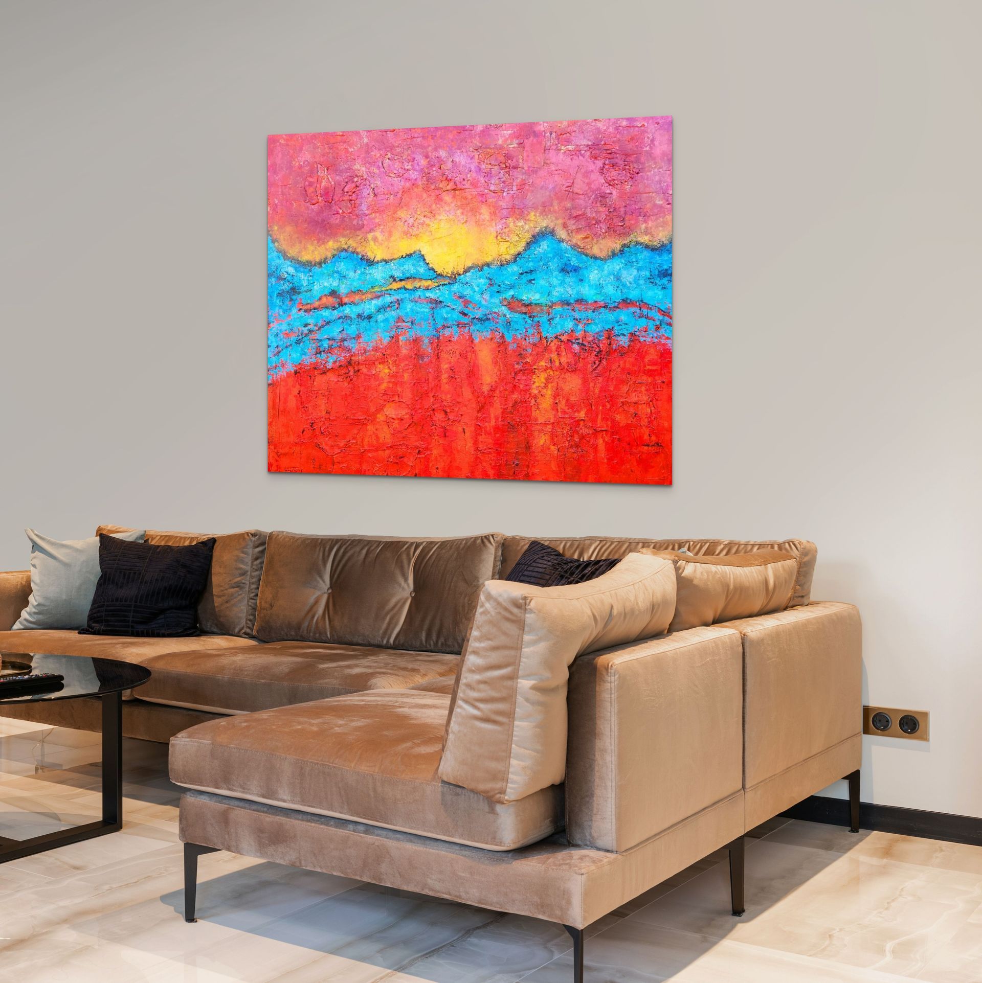 A sectional sofa faces a colorful abstract landscape painting with bands of pink, yellow, blue, and orange on a wall.