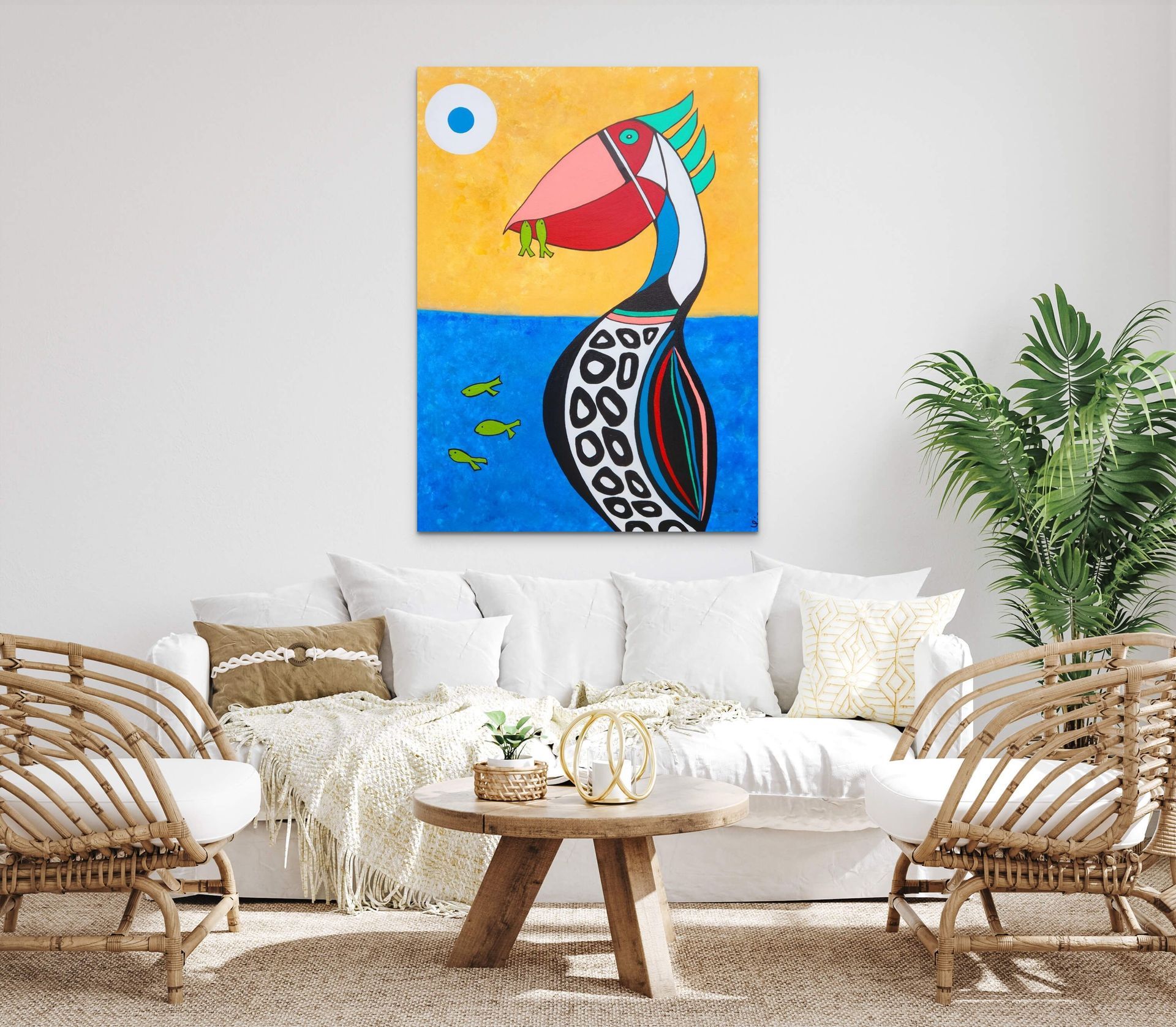A stylized painting of a patterned bird on a yellow and blue background hanging above a white sofa in a bright room.