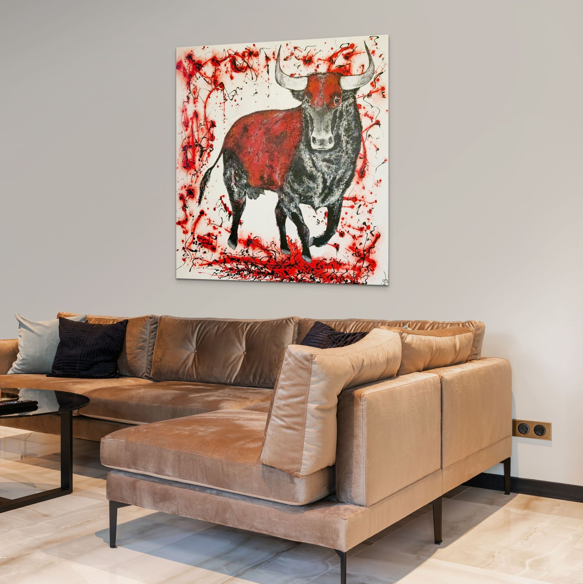 A painting of a bull with red accents hangs on a light wall above a beige sectional sofa in a modern living room.