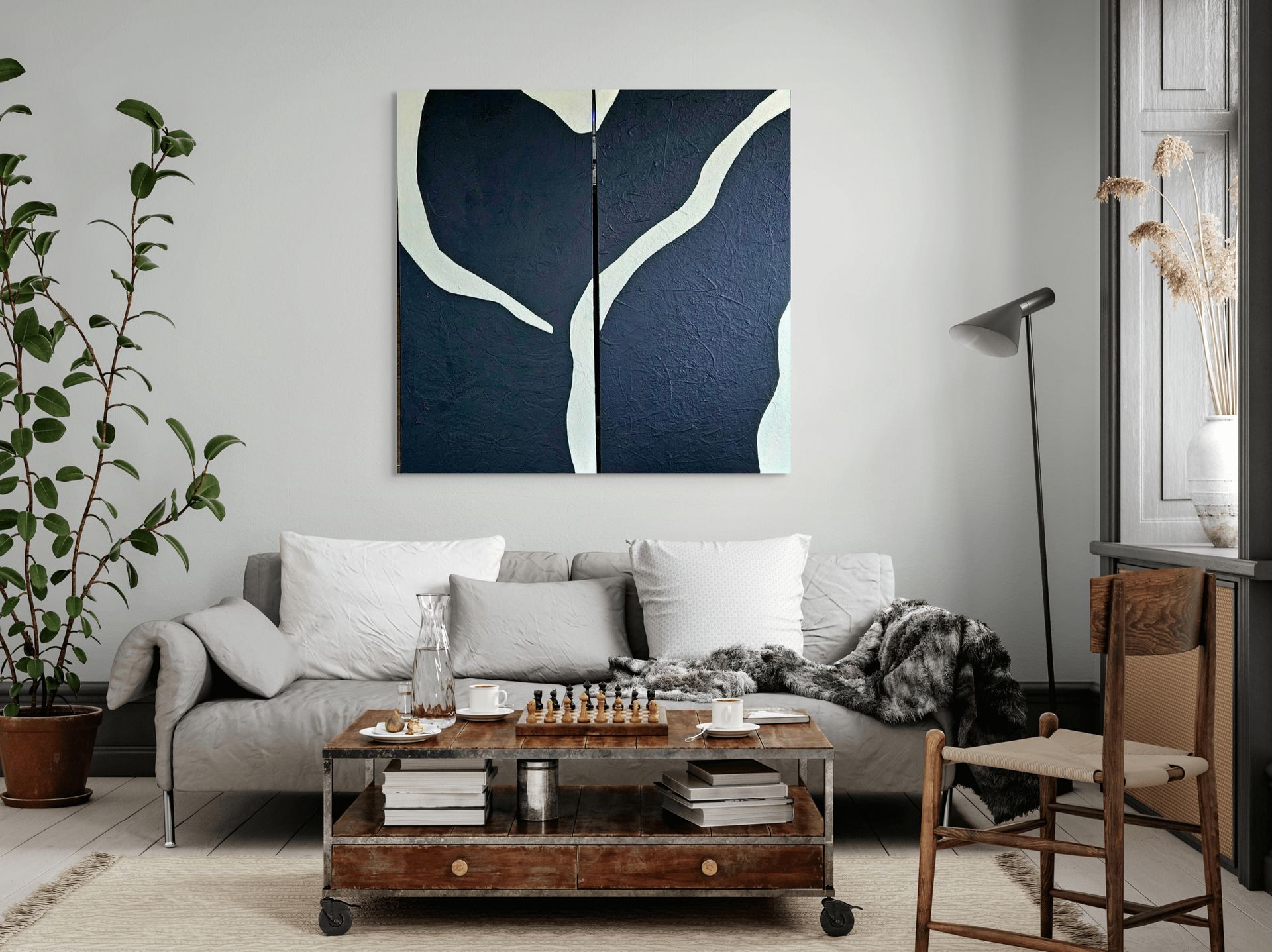 A gray sofa in a living room sits beneath two dark blue abstract paintings with white curved lines.