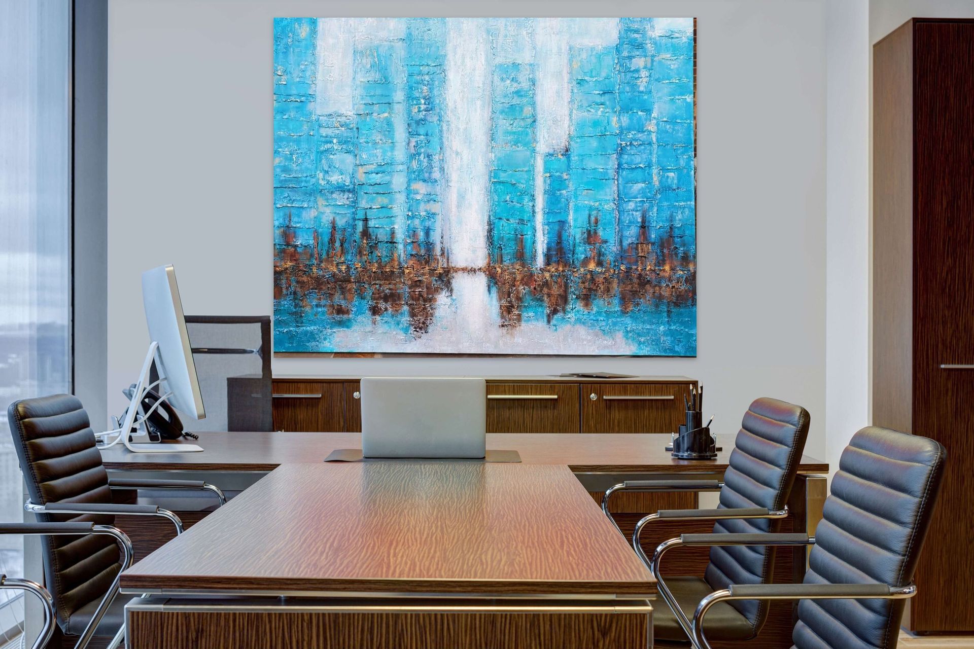 Modern office with a wooden desk, black chairs, and a large abstract painting of a blue city skyline on the wall.