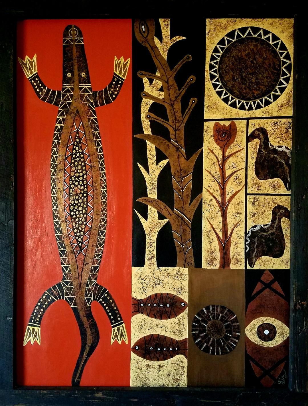 A modern living room features a wooden cabinet, a grey armchair, a small wooden chair, and framed ethnic art on the wall.
