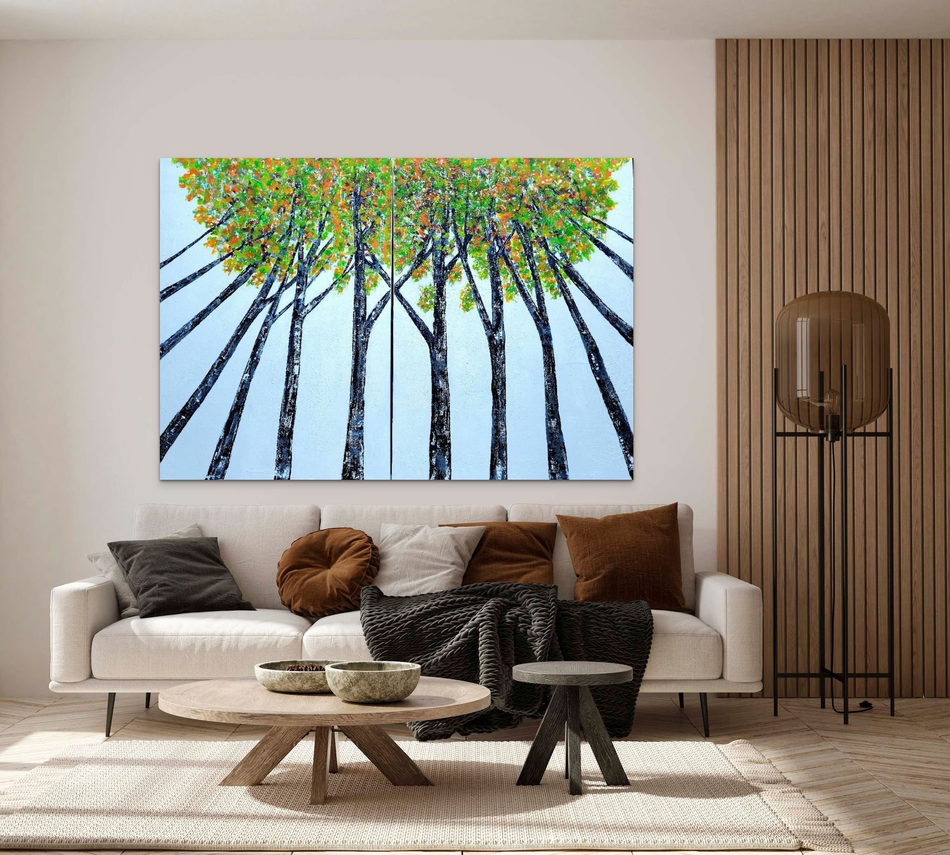 A modern living room with a white sofa, round pillows, a wooden coffee table, and a large abstract forest painting.