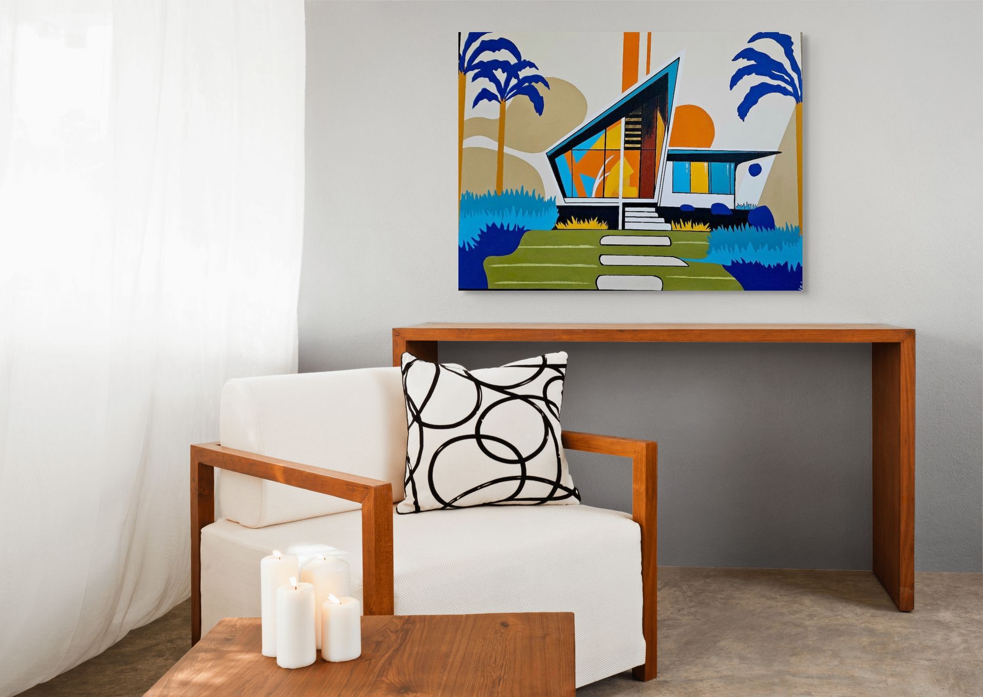 A mid-century modern style art print hangs above a wooden console table next to a white chair with a patterned pillow.