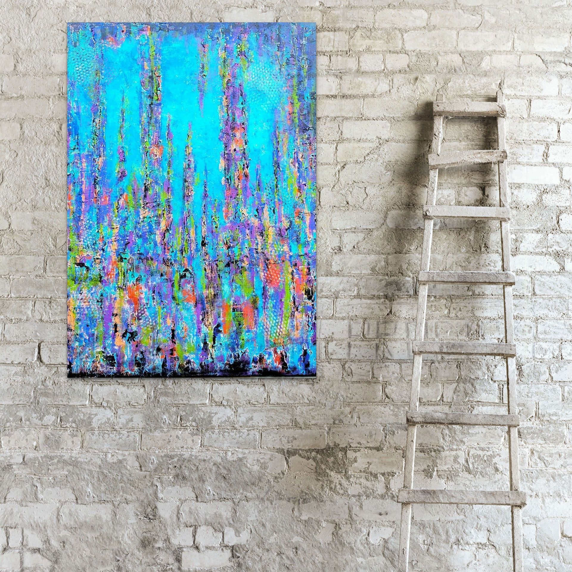 An abstract, multi-colored painting hangs on a textured, white brick wall next to a wooden ladder.