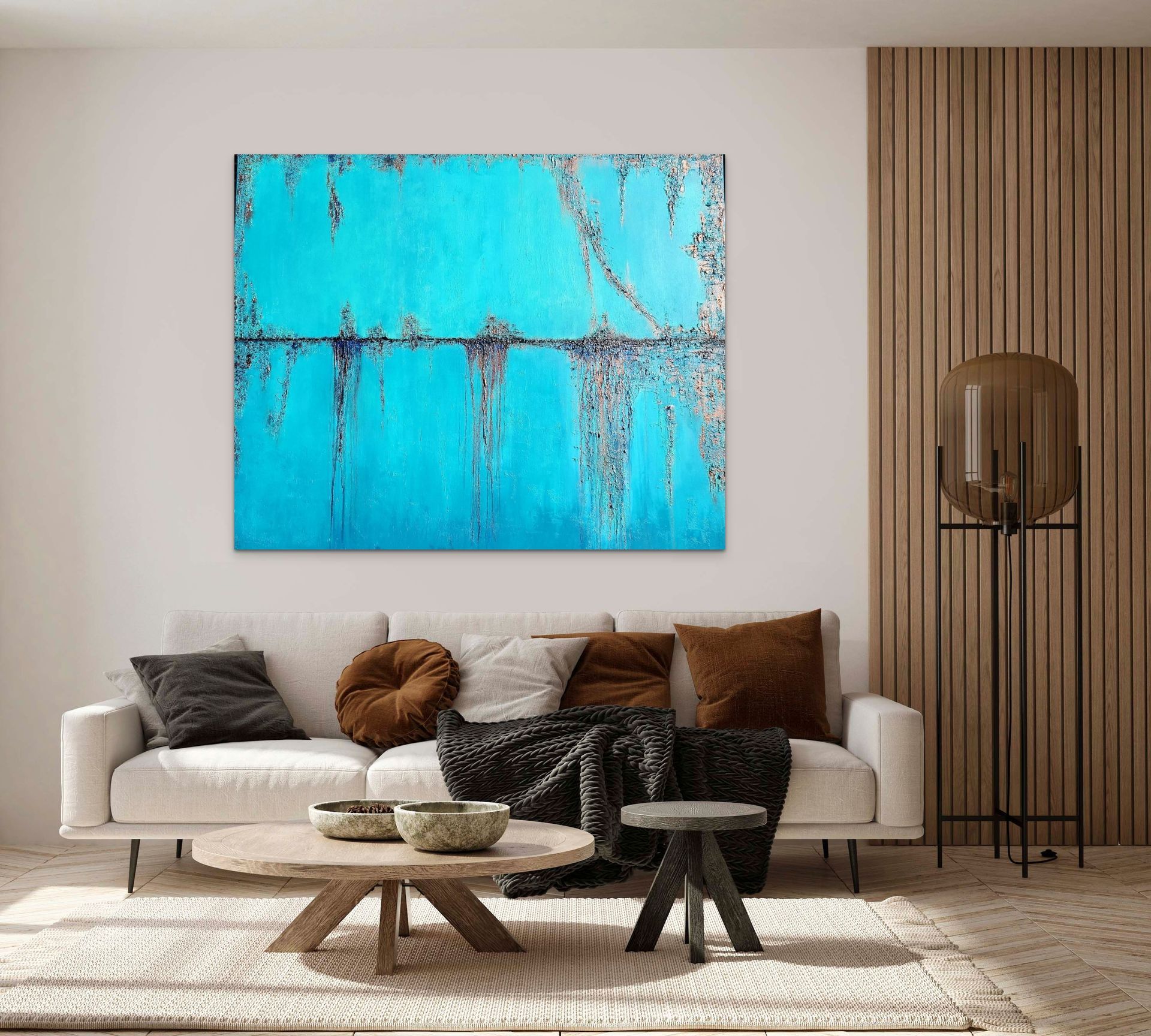A modern living room with a white sofa, neutral pillows, a round coffee table, and a large teal abstract wall painting.