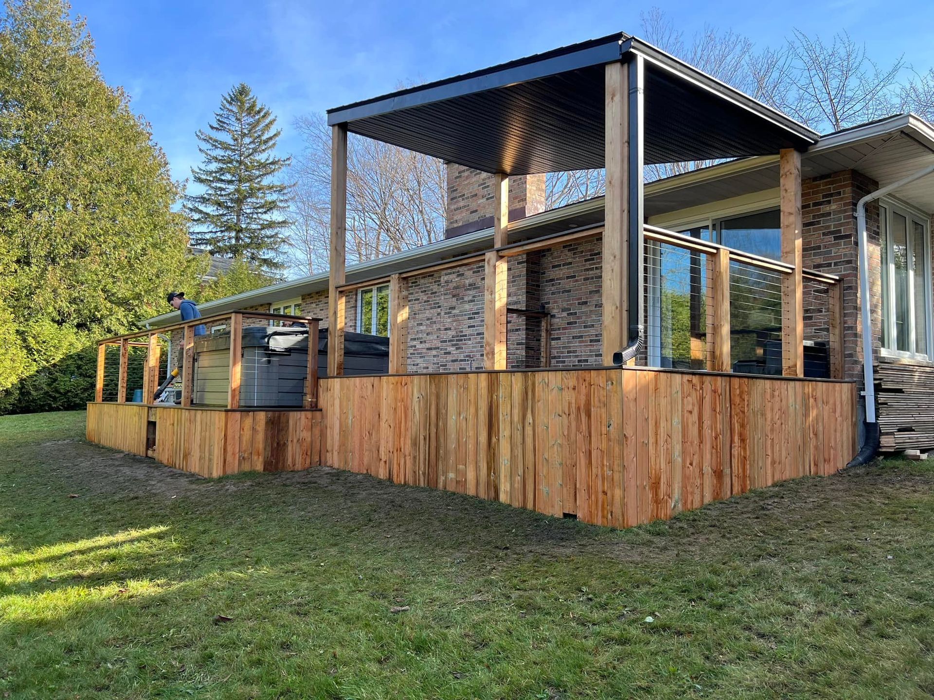 A house with a wooden deck and fence in front of it.