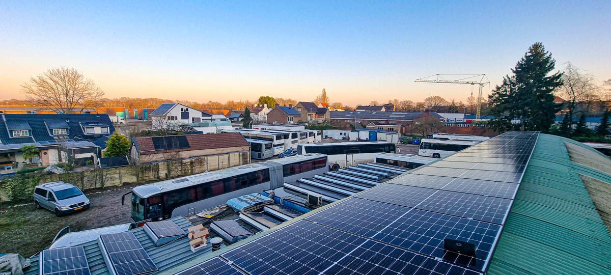 Er liggen veel zonnepanelen op het dak van een gebouw.