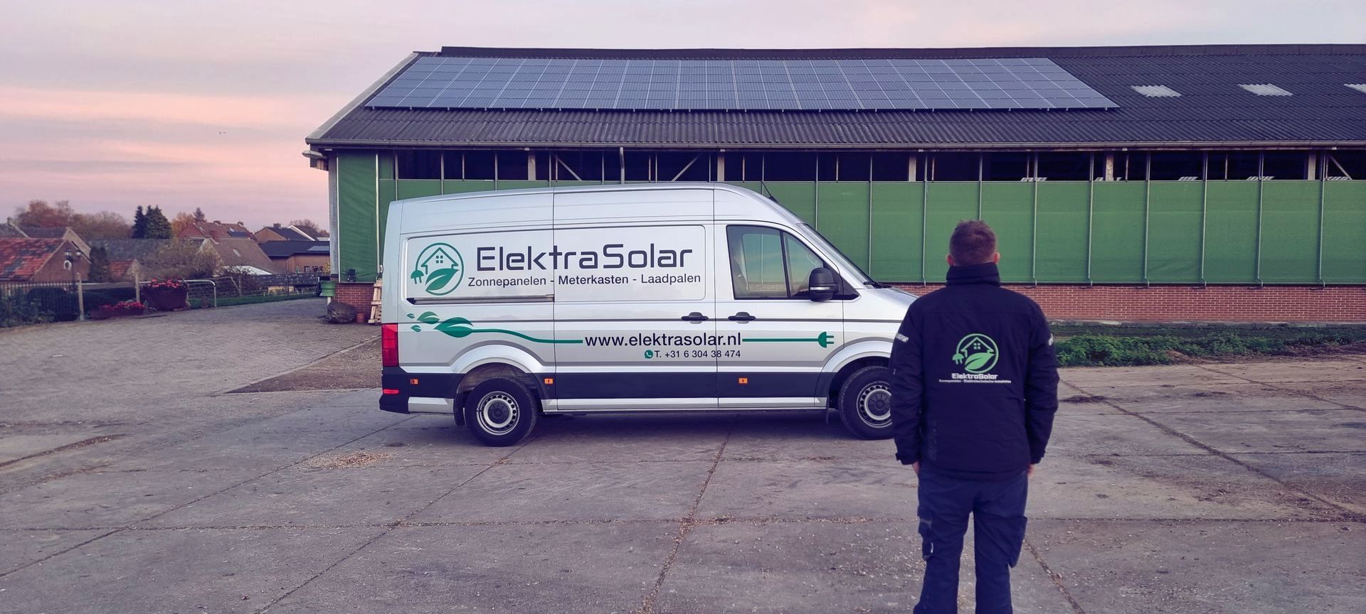 Een man staat voor een busje met zonnepanelen op het dak.
