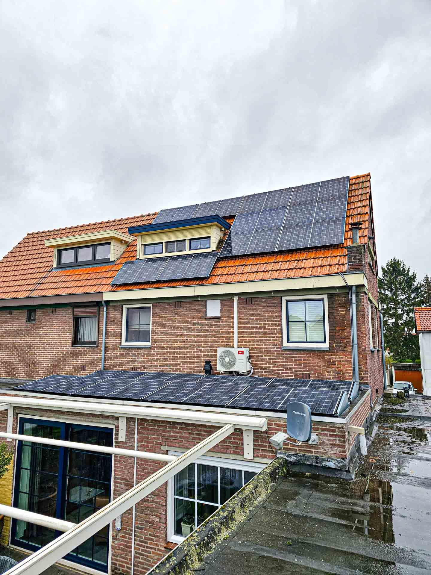 Een bakstenen huis met zonnepanelen op het dak.