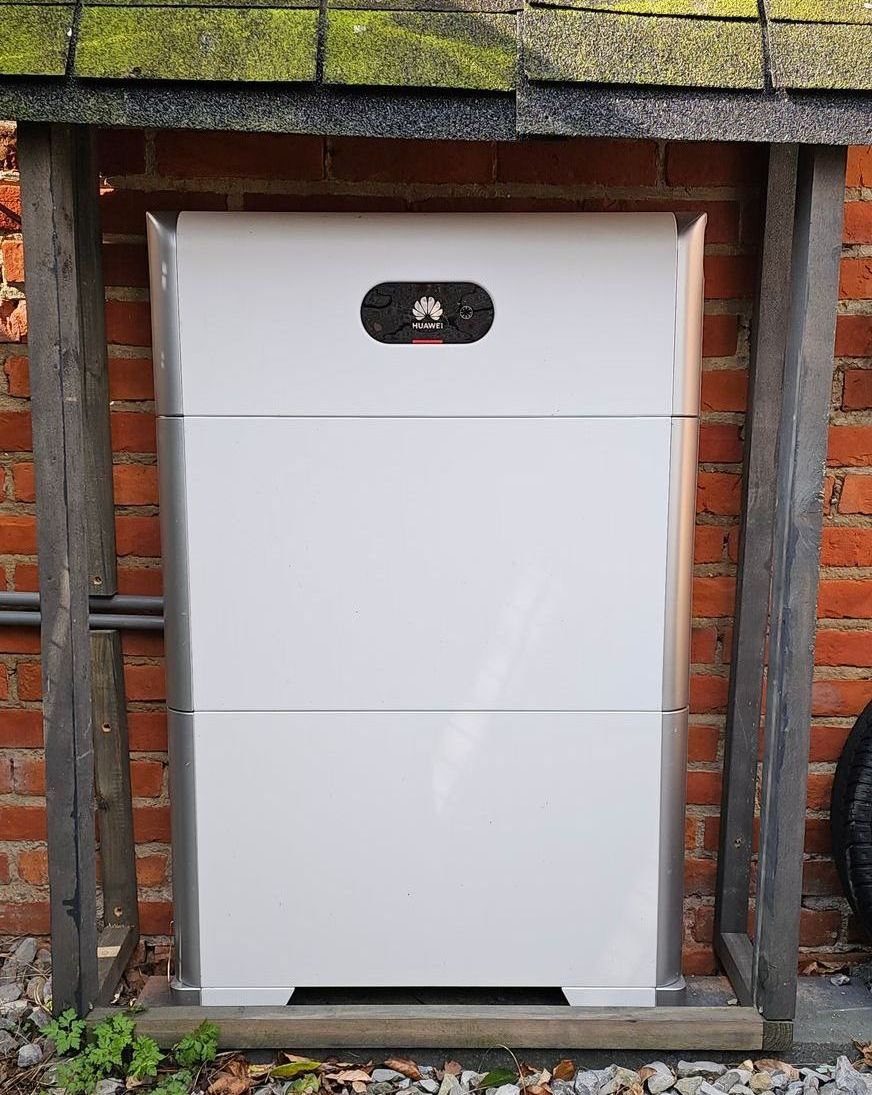 Een grote witte doos staat op een bakstenen muur.