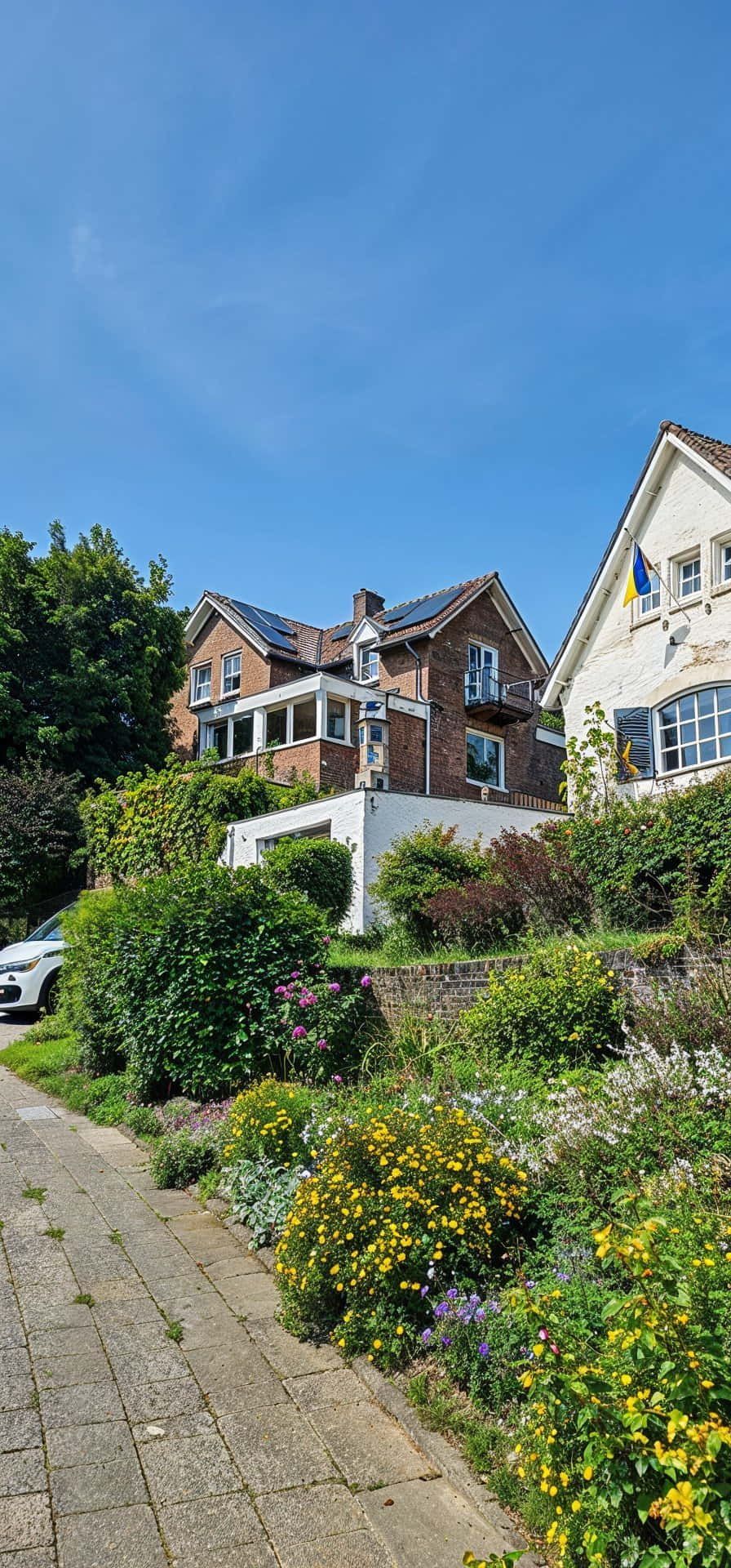 Een groot huis staat op de top van een heuvel naast een tuin.