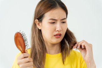 a woman combing her hair with a wooden comb