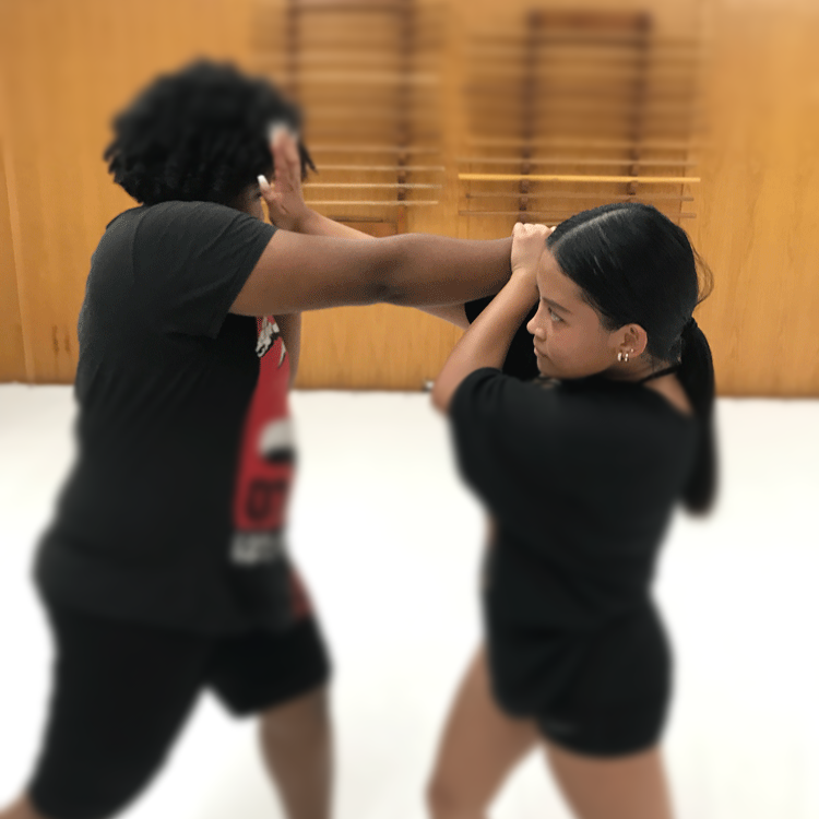 Young woman executing a precise counter technique against an opponent during Filipino martial arts training , showcasing focus, strategy, and problem-solving under pressure.