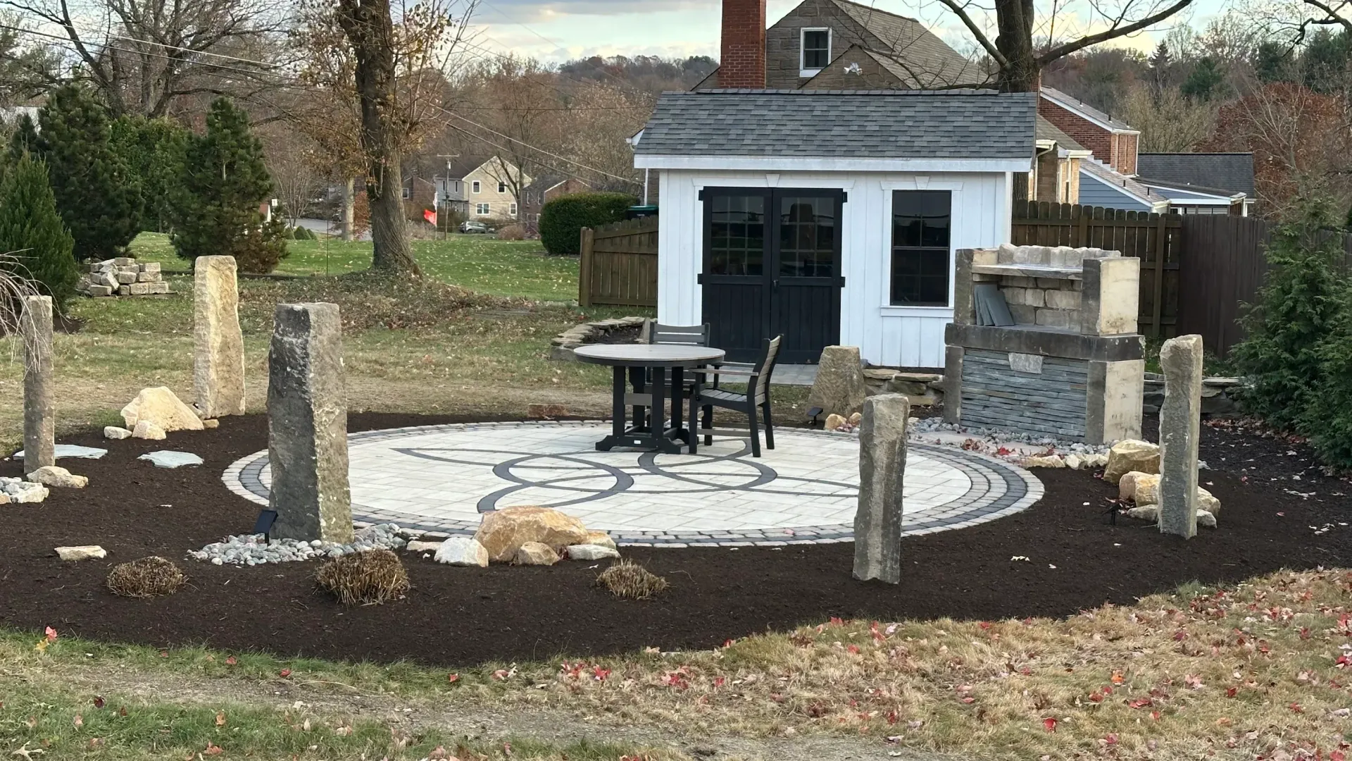 Memorial garden with stone seating, circular white gravel path, and a small white building in the background