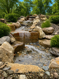 Poolside water feature spilling into a turquoise swimming pool