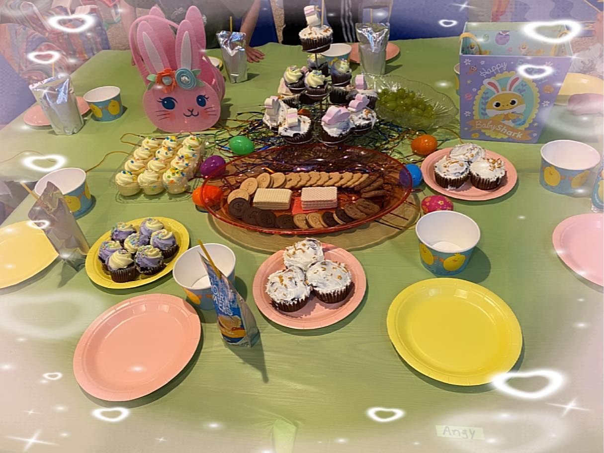 Pastel Easter-themed dessert table with cupcakes, cookies, and bunny decorations